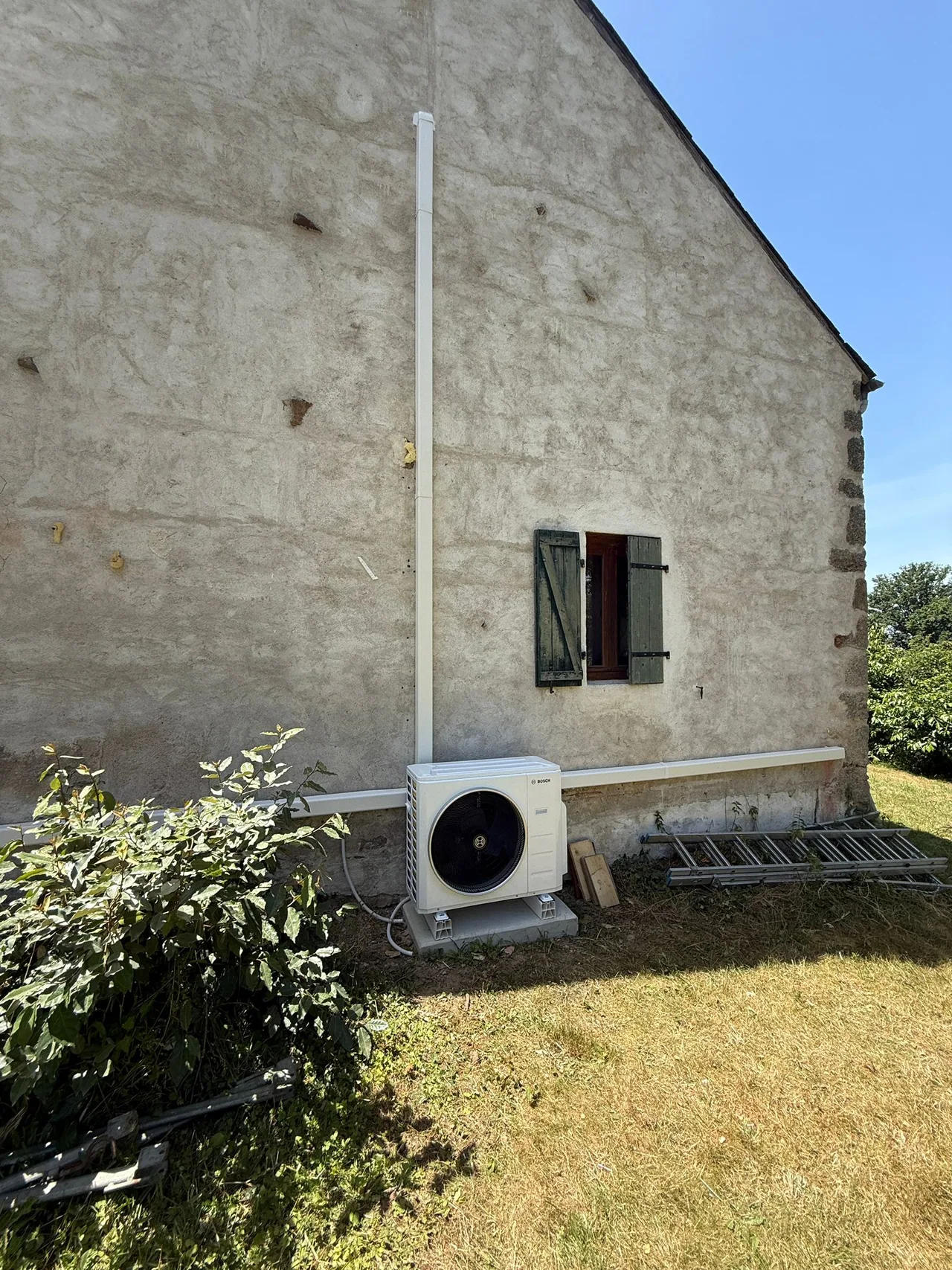 Unité extérieure de climatisation réversible Bosch à Deneuille-les-Mines Unité extérieure Bosch pour climatisation réversible posée sur une maison ancienne à Deneuille-les-Mines