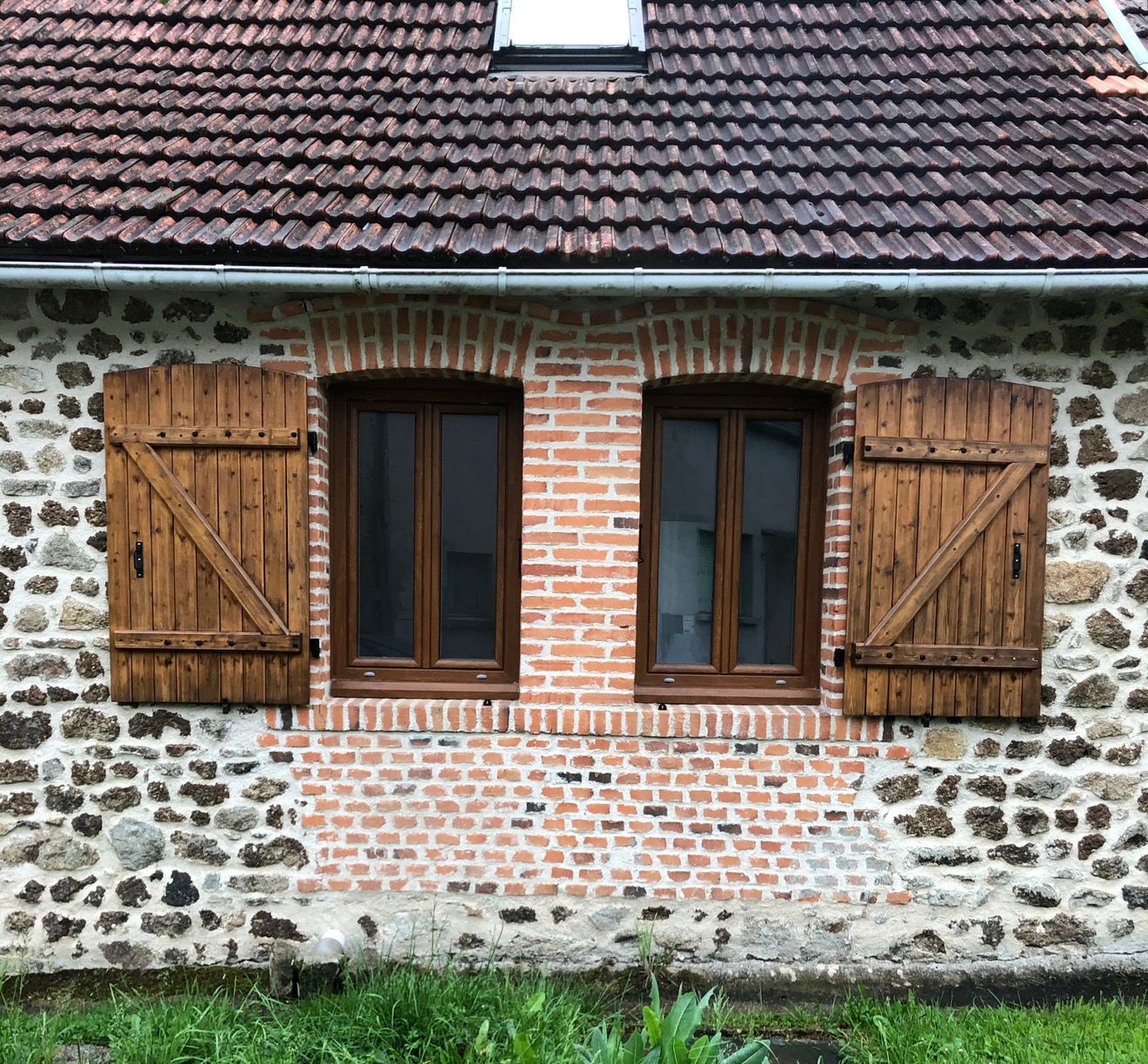Façade ancienne avec fenêtres PVC couleur chêne doré à Saint-Loup dans la Creuse